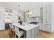 Modern kitchen with large island, white cabinets, and hardwood floors at 8917 Grand Highland Way, Wake Forest, NC 27587