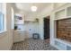 Bright laundry room with white cabinets, patterned floor tile, and built-in shelving at 34 Chestnut Creek Way, Chapel Hill, NC 27516