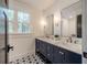 Double vanity with navy blue cabinets, white quartz countertop, and patterned floor tile at 34 Chestnut Creek Way, Chapel Hill, NC 27516