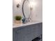 Gray double vanity with quartz countertop, modern faucets, and a large round mirror at 34 Chestnut Creek Way, Chapel Hill, NC 27516