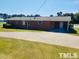 Rear view of brick home with large yard and driveway at 2164 Ray Rd, Spring Lake, NC 28390