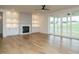 Spacious living room with hardwood floors, fireplace, built-in shelving, and sliding glass doors at 180 Pondhurst Ln, Fuquay Varina, NC 27526