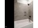 Bathroom with a shower/tub combo and grey tile at 180 Pondhurst Ln, Fuquay Varina, NC 27526