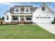 Two story home with white siding, a large garage, and manicured lawn at 180 Pondhurst Ln, Fuquay Varina, NC 27526