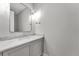 Stylish powder room with marble countertop, a floating vanity, and a sleek mirror at 8417 Portmarnock Ct, Wake Forest, NC 27587