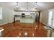 Open concept kitchen with island, hardwood floors, and stainless steel appliances at 617 Casey Ln, Mebane, NC 27302