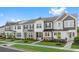 Row of charming townhouses with gray siding, stone accents, and manicured lawns at Tbd Channel Drop Dr # 123, Clayton, NC 27520