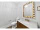 Chic powder room with marble vanity, gold accents, and decorative mirror at 2651 Marchmont St, Raleigh, NC 27608