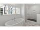 Luxurious bathroom with soaking tub, walk-in shower, and marble flooring at 2408 Everett Ave, Raleigh, NC 27607