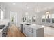 Open concept kitchen with island, stainless steel appliances, and white cabinetry at 2408 Everett Ave, Raleigh, NC 27607