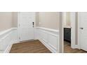 Bright entryway with wainscoting, hardwood floors, and powder room at 333 Marbella Grove Ct, Durham, NC 27713