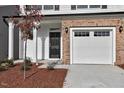 Two-car garage with white door and brick facade at 333 Marbella Grove Ct, Durham, NC 27713