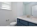 Modern powder room with blue vanity and granite countertop at 333 Marbella Grove Ct, Durham, NC 27713