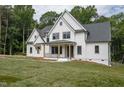 White farmhouse with a gray roof, black windows, and front porch at 13629 Old Creedmoor Rd, Wake Forest, NC 27587