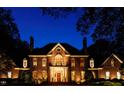 Brick house with columns and lighting, showcasing its elegant appearance at night at 2441 W Lake Dr, Raleigh, NC 27609