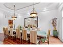 Formal dining room with long table, chandelier, and hardwood floors at 40002 Worth, Chapel Hill, NC 27517