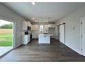 Modern kitchen with white cabinets, quartz countertops, and stainless steel appliances, and sliding glass door to backyard at 40 Longbow Dr, Middlesex, NC 27557