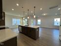 Modern kitchen with island, stainless steel appliances, and hardwood floors at 116 Commons Cir # 229, Clayton, NC 27520