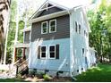 Two-story house with gray siding, showing side elevation and windows at 7647 Cummings Dr, Mebane, NC 27302