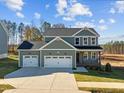 Two-story craftsman style home with gray siding and a two-car garage at 305 Sutherland Dr, Franklinton, NC 27525