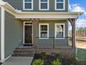 Inviting front porch with dark brown door and brick steps at 305 Sutherland Dr, Franklinton, NC 27525