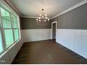 Bright dining room features hardwood floors, wainscoting, and a chandelier at 6059 Scalybark Road, Durham, NC 27712