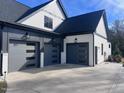 Three-car garage with modern panel doors and concrete driveway at 43 Laurel Knoll Dr, Pittsboro, NC 27312