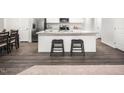 Modern kitchen with island, stainless steel appliances, and hardwood floors at 205 Suburban Meadows Pass, Wendell, NC 27591