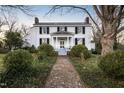 White farmhouse with brick pathway and landscaping at 6720 Mebane Oaks Rd, Mebane, NC 27302