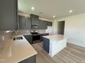Modern kitchen with island and stainless steel appliances at 352 Chestnut Oak Ln, Lillington, NC 27546