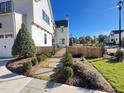 Side yard with a paved walkway, landscaping, and a metal gate at 3401 Makers Cir, Raleigh, NC 27612