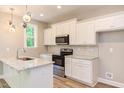 Modern kitchen with white cabinets, granite countertops, and stainless steel appliances at 206 Cardinal Ct, Oxford, NC 27565