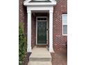 Green front door entryway with brick facade and small porch at 1331 Still Monument Way, Raleigh, NC 27603