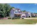 Two story house with gray siding and landscaping at 104 Abbeville Ln, Holly Springs, NC 27540