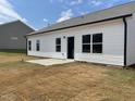 Rear view of a single-story house with white siding, a patio, and a small yard at 122 Vega Loop # 61, Sanford, NC 27330