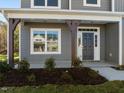 Covered front porch with dark brown columns and a dark-colored front door at 530 Husketh Rd, Youngsville, NC 27596