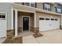 Townhouse exterior with a stone and siding facade, attached garage, and landscaping at 818 Pryor St # 55, Mebane, NC 27302