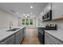 Modern kitchen with gray cabinets, quartz countertops, and stainless steel appliances at 818 Pryor St # 55, Mebane, NC 27302