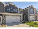 Two story townhome with gray siding, stone accents, and a two car garage at 2321 Sugar Cone Way, Fuquay Varina, NC 27526
