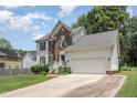 Two story brick and white sided home with attached garage and driveway at 2205 Moon Water Way, Garner, NC 27529
