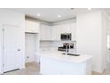 Modern white kitchen with stainless steel appliances and an island at 218 Sweetbay Tree Dr, Wendell, NC 27591