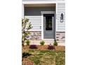 Modern gray front door with stone accents and landscaping at 218 Sweetbay Tree Dr, Wendell, NC 27591