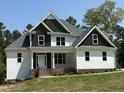 Two-story home with white and dark gray siding, brick accents, and large windows at 190 Whistlers Cv, Louisburg, NC 27549
