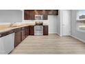 Modern kitchen with dark brown cabinets, stainless steel appliances, and light flooring at 3915 Swinton St, Raleigh, NC 27616