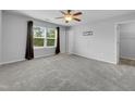 Spacious bedroom with carpeted floor, large window, ceiling fan, and walk-in closet at 3915 Swinton St, Raleigh, NC 27616