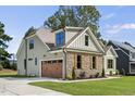 Two-story craftsman home with stone accents and a large wooden garage door at 112 Lambert Ln, Fuquay Varina, NC 27526