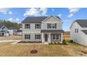 Two-story home with gray siding, stone accents, and a covered front porch at 535 Husketh Rd, Youngsville, NC 27596