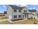 View of a two-story gray home with black shutters and a stone and columned front porch at 535 Husketh Rd, Youngsville, NC 27596