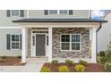 Covered front entry with stone accents, gray door, sidelights, and white columns at 535 Husketh Rd, Youngsville, NC 27596