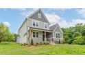 Two-story house featuring gray siding, stone accents, and a welcoming front porch at 242 Lakestone Estates, Pittsboro, NC 27312